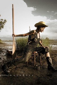 girl in boots and cowbow hat in mud